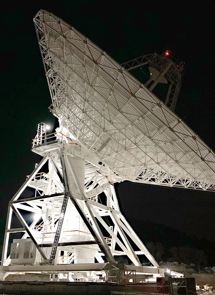 Освещённая наземная антенна DSS-53 сети дальней космической связи возле Мадрида ночью.